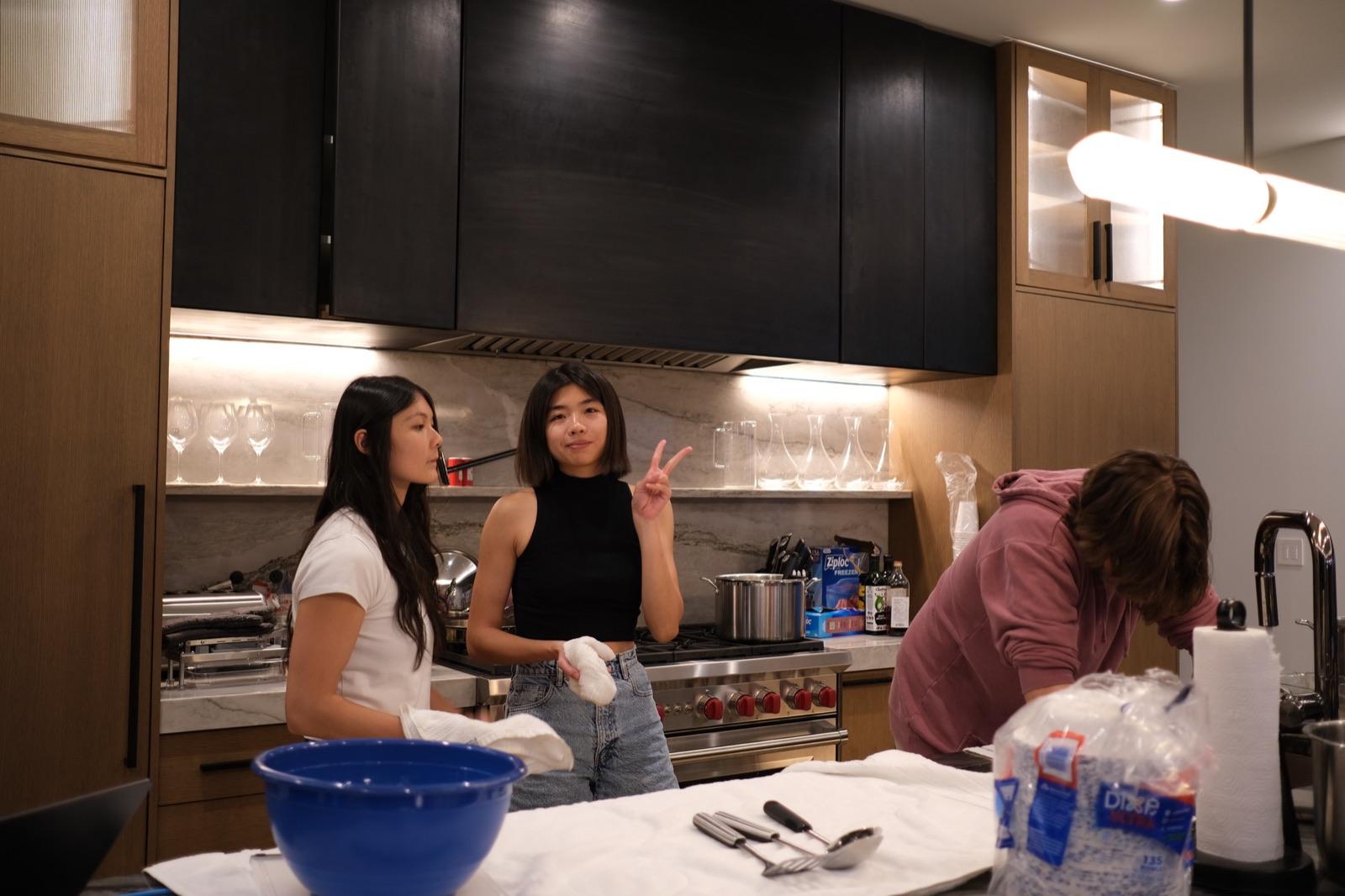 Three teammates cooking together in the kitchen