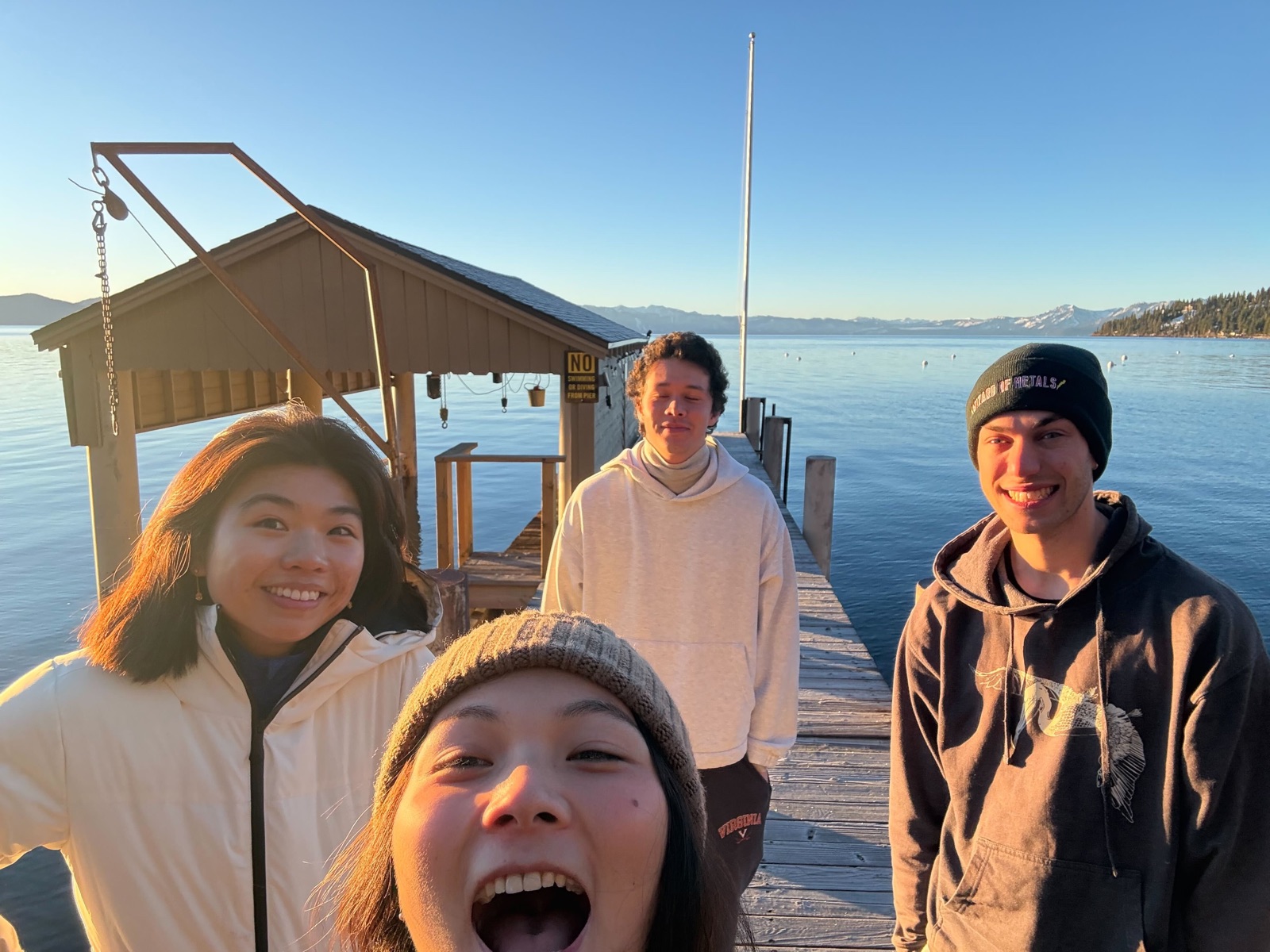 Four Replo teammates on a lakeside dock at sunset in Lake Tahoe